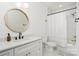 Clean bathroom with a bathtub, shower, white cabinets, and a round mirror at 643 Tennyson Dr, Charlotte, NC 28208