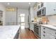 Bright kitchen with white cabinets, marble countertops and stainless steel appliances at 2903 Thayer Dr, Waxhaw, NC 28173