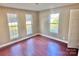 Simple bedroom with hardwood floors and two large windows at 722 Tanglewood Dr, Salisbury, NC 28144