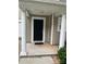 Front entry with black door, white columns and small porch at 14011 Pinyon Pine Ln, Charlotte, NC 28215
