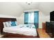 Bedroom with wooden bed, teal curtains, and hardwood floors at 1846 Colin Creek Ln, Charlotte, NC 28214