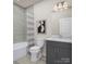 Bathroom with gray vanity, white toilet, and striped shower curtain at 2131 Endeavor Run, Charlotte, NC 28269