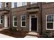 Brick front exterior of townhome with black front door and landscaping at 2212 Noble Townes Way, Charlotte, NC 28262