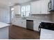 White kitchen with stainless steel appliances and wood flooring at 2220 Noble Townes Way, Charlotte, NC 28262