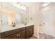 Double vanity bathroom with dark brown cabinets and a large mirror at 9036 Bradstreet Commons Way, Charlotte, NC 28215