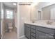 Double vanity bathroom with grey cabinets and white countertop at 9038 Dulwich Dr # Ken0069, Charlotte, NC 28215