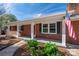 Brick ranch house with covered porch, red door, and American flag at 3026 Hazel Dr, Shelby, NC 28152