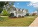 White Victorian home with a spacious yard and mature trees at 305 S Main St, Davidson, NC 28036