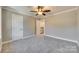 Bedroom with grey carpet, ceiling fan, and access to upper level at 1830 Ebenezer Rd, Rock Hill, SC 29732