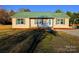 Beige house with green roof, covered porch, and landscaped yard at 2172 Robert Usher Rd, Lancaster, SC 29720