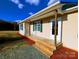 Beige house with green roof, covered porch, and landscaped yard at 2172 Robert Usher Rd, Lancaster, SC 29720