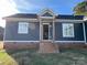 Newly built home with gray siding, brick base, and front porch at 1517 Sugarfarm Rd, Catawba, NC 28609