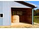 Interior of a metal building with hay bale and shelving at 1627 Peden Bridge Rd, Chester, SC 29706
