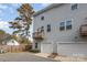 Side view of gray townhome showcasing balcony, garage, and mature tree at 2410 Via Dei Conte Aly, Charlotte, NC 28205