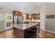 Modern kitchen with granite countertops, wooden cabinets, and a large island with seating at 169 Rimmer Farm Rd, Troutman, NC 28166