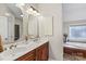 Double vanity bathroom with oval mirrors, soaking tub, and walk-in shower at 169 Rimmer Farm Rd, Troutman, NC 28166