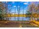 Serene lake view from the backyard, surrounded by autumn trees at 169 Rimmer Farm Rd, Troutman, NC 28166