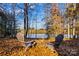 Relaxing fire pit with lake view surrounded by colorful autumn leaves at 169 Rimmer Farm Rd, Troutman, NC 28166