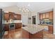 Modern kitchen with granite countertops, wooden cabinets, and a large island with seating at 169 Rimmer Farm Rd, Troutman, NC 28166