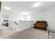 Open loft area with a brown recliner and glass-top coffee table at 113 Dublin Ct, Statesville, NC 28677