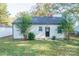 White bungalow with a black door, surrounded by green lawn and trees at 571 Hillandale Ne St, Concord, NC 28025