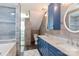 Modern bathroom with blue double vanity, walk-in shower, and soaking tub at 8443 Middleton Cir, Harrisburg, NC 28075