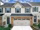 Two-story townhome with neutral siding, stone accents, and a two-car garage at 128 Inlet Point Dr, Tega Cay, SC 29708