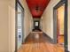 Long hallway with hardwood floors and red accent ceiling at 5198 Old Hickory Rd, Lancaster, SC 29720