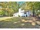 White house exterior, nestled among lush green trees, showcasing curb appeal at 11116 Vista Canyon Dr, Charlotte, NC 28226