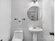 Small bathroom with a round mirror and white pedestal sink at 1124 Woodwinds Dr, Waxhaw, NC 28173