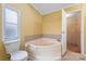 Bathroom with corner tub and access to laundry at 5112 Green Leaf Ct, Mount Holly, NC 28120