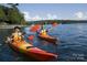 Couple kayaks on a lake with lush green trees and sailboats in the background at 7112 Brookview Ln, Sherrills Ford, NC 28673