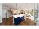 Open concept kitchen features a large island with a farmhouse sink, stainless steel appliances, and hardwood floors at 8024 Plymouth Dr, Sherrills Ford, NC 28673