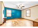 Bright bedroom with hardwood floors, teal accent wall, and two windows at 143 Ponokah Ln, Statesville, NC 28677