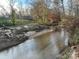 Serene creek flows through a wooded area adjacent to a golf course at 143 Ponokah Ln, Statesville, NC 28677