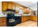 Kitchen with wood cabinets, granite countertops, and black appliances at 143 Ponokah Ln, Statesville, NC 28677