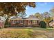 Brick ranch home with a landscaped yard and inviting front porch at 1532 Starbrook Dr, Charlotte, NC 28210
