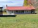 Ranch house with red metal roof, gray stone siding, and screened porch at 133 Elmwood Rd, Statesville, NC 28625