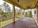 Spacious covered porch overlooks a serene lake and wooded area at 17422 Hawkwatch Ln, Charlotte, NC 28278