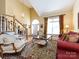 Living room with hardwood floors, red couch, and large windows at 3534 Nestling Ln, Fort Mill, SC 29708