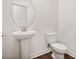 Clean bathroom with pedestal sink, toilet, and round mirror at 1050 Bull Dog Ln, Wingate, NC 28174