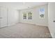 Simple bedroom with gray carpet, double doors and windows at 1050 Bull Dog Ln, Wingate, NC 28174
