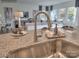 Modern kitchen sink and faucet with view into living area at 143 Dogwood Grove Pl, Troutman, NC 28166