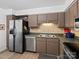 Galley kitchen with stainless steel appliances and light brown cabinets at 1525 Lansdale Dr # F, Charlotte, NC 28205