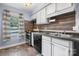 Galley kitchen with white cabinets, dark countertops, and wood accent wall at 2705 North Center St # 74, Hickory, NC 28601