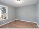 Well-lit bedroom featuring laminate wood flooring and a window at 5136 Wheat Sw Dr, Concord, NC 28027