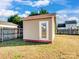 Tan colored storage shed with white door in backyard at 5136 Wheat Sw Dr, Concord, NC 28027