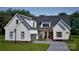 Two-story farmhouse with white siding, gray garage door, and a covered porch at 119 Ll Harwell Rd, Gastonia, NC 28056