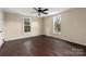 Bedroom with ceiling fan, dark floors, and two windows at 305 Elm St, Lancaster, SC 29720