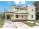 Two-story yellow house with front porch, driveway, and landscaping at 305 Elm St, Lancaster, SC 29720